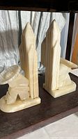 Pair of cream colored onyx bookends with Mexican themed figures and cactus shapes.