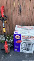Photo showing the electric weedwhacker alongside the boxed All-Pro portable propane convection heater.
