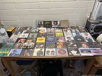 Wide angled photo of all CDs laid out on table showing variety and quantity in the lot