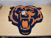 Photo of new Chicago Bears shaped rug showing bear head logo and colors.