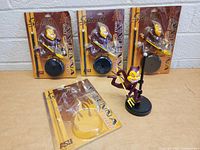 Four ASU Sparky vehicle antenna figures, three in original blister packaging and one out of package mounted on a black circular base with antenna.
