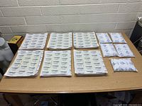Top view of 12 different sizes of white Thermosafe PolarPack cold packs laid on a table.