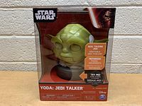 Front view of Star Wars Yoda Jedi Talker toy in clear box showing the toy and packaging details.