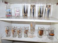 Wide shot of all barware including tumblers, mugs, and wildlife design glasses showing the full lot