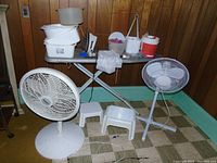 Overview of ironing board, fans, stools, basins, and related laundry items