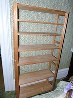 Front view of wooden bookshelf showing six flat wooden shelves and side supports.
