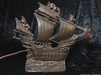 Front angled view of the antique cast iron sail boat lamp showing detailed sails, ship body and base.