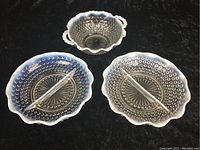 Three hobnail glassware pieces against dark background showing white rim and blue tint with raised circular hobnail pattern.