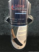 Photo of the sock aid device in packaging showing front branding and product name.