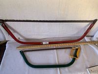 Two bow saws laid out side by side measuring approximately 36 inches and 26 inches, showing overall condition and frame colors.