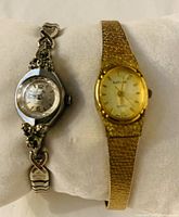 Two vintage ladies wristwatches, one silver-tone Invicta 17 jewel Swiss made with ornate band and the other gold-tone Baylor with textured band.