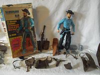 View of Dangerous Dan figure standing with original box behind and accessories arrayed in front on white background