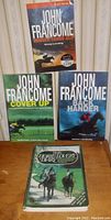 Four books displayed: three John Francome paperback novels and one hardcover horse lover's diary book.