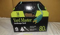 Front view of Yard Master landscape extension cord in original black and green packaging showing 16 gauge and 80 ft length.