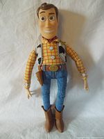Front view of Sheriff Woody figure showing head, detailed shirt, vest, jeans, belt, and boots.