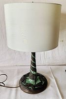Full view of the lamp showing white shade, mosaic tiled stem, and bronze-tone base.