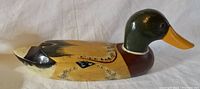 Side profile of the carved wooden duck decoy showing detailed paintwork on wing and body.
