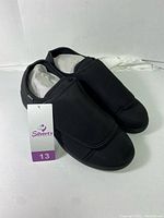 Pair of black Silvert's adaptive slippers size 13 with tag, displayed side by side, showing outer sides and top view.
