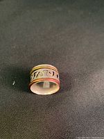 Top view of sterling silver ring set against a black background showing stamped marking and stacked band design.