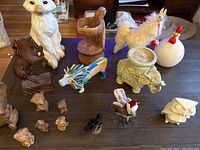 Overview of animal ornaments including hand carved bears, wooden arctic fox, flip flop lion, wooden turtle, elephant stand, and small bird figurines.