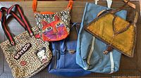 All five bags arranged on wooden floor for overview
