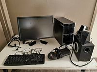 Overall setup showing monitor, tower, keyboard, mouse, speakers and surge protector on table