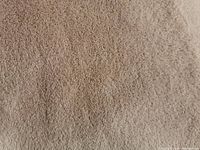 Close-up image showing the texture of the light brown brushed fleece material of the blanket.