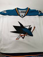 White San Jose Sharks NHL jersey with teal and black trim, featuring team shark logo front and center.