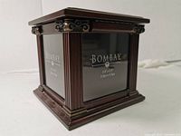Photo of wooden photo box by Bombay with decorative corners and glass panels displaying brand name and photo size