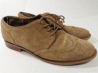 Side view of tan suede leather men's shoes with lace-up, showing entire shoe and wooden heels.