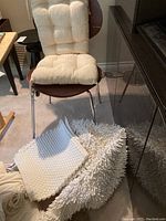 Four items arranged with the chair cushions placed on a chair and the two mats on the floor in front of it, showing texture and size.