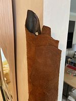 Close-up photo showing texture of leather bolt with a smooth dark brown side and suede lighter brown side.