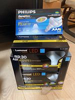 Photo showing one box of Philips DuraMax indoor flood lights and two boxes of Luminus Elite LED BR30 bulbs.