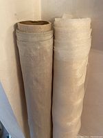 Two fabric bolts standing upright, one silk (left) and one organza (right), wrapped around cardboard tubes.