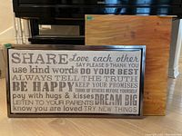 Wall art word print on canvas in metal-colored plastic frame, showing positive affirmations in various fonts and shades of gray.