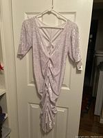 Front view of white crushed velvet dress showing deep V-neck, short sleeves and shirred ruching detail front