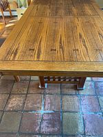 Top view of the wooden dining table showing the leaf inserted, highlighting the grain pattern and inset details