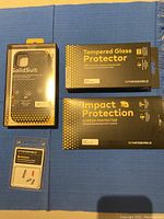 Rhinoshield packaging for tempered glass screen protector, impact protection screen protector, and replacement buttons.