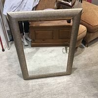 Full view of the rectangular mirror showing the wood frame with patina and reflective glass.