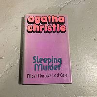 Front cover photo of 'Sleeping Murder' by Agatha Christie, featuring purple/pink cover with bold colorful text.