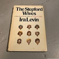 Front cover of 'The Stepford Wives' by Ira Levin, showing title, author and cover art with nine stylized female faces.