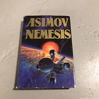 Photo of the book cover showing the title 'ASIMOV NEMESIS' with a space-themed illustration.