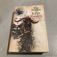 Front cover of 'The Magus' showing artistic dust jacket with some wear and discoloration.