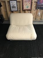 Front view of vintage MCM cloud chair showing plush, padded cream upholstery with visible dirt and stains.