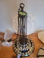 Full view of Tiffany style stained glass hanging lamp laid on floor showing full chain and glass shade