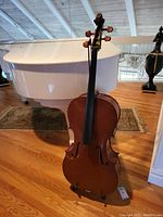 Full-view of wooden cello showing body shape, f-holes and fingerboard.