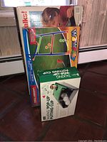 Photo showing boxed Wowplay Ladder Toss and the Talking Pop-up Putting Cup game in green box