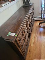 Top view of the wooden triple dresser showing scratches and brass pulls