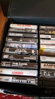 Photo showing assortment of cassette tapes including Men At Work, Black Sabbath, George Harrison, Foreigner, and Aerosmith