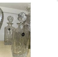 Two Sterling brand lead crystal wine decanters with diamond cut pattern and faceted spherical stoppers.